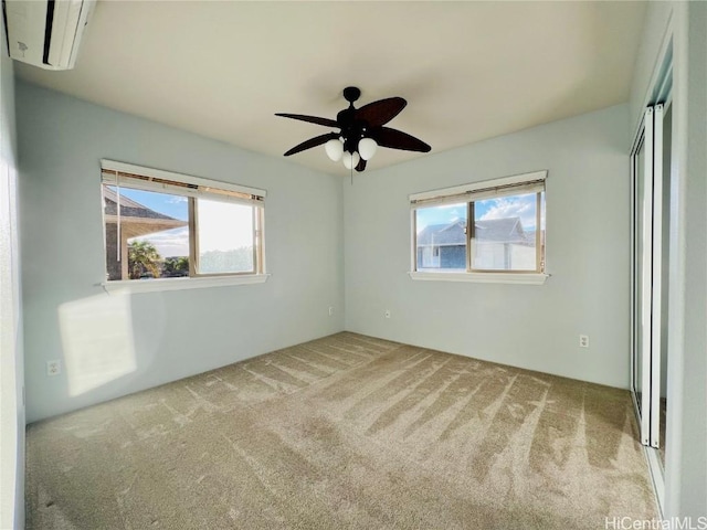 unfurnished bedroom featuring a wall mounted air conditioner, ceiling fan, and light carpet