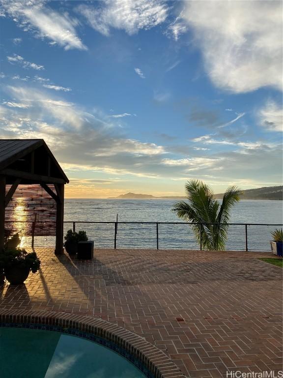 patio terrace at dusk with a gazebo and a water view