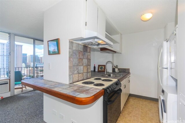 kitchen with sink, tile countertops, a textured ceiling, electric stove, and white cabinets