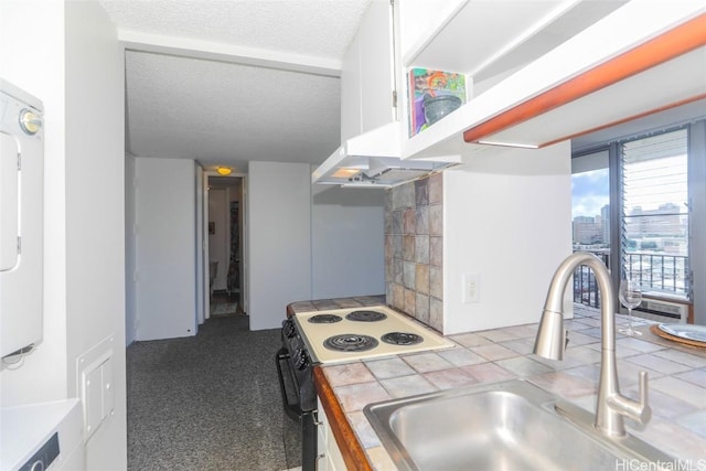 kitchen with electric range, sink, tile countertops, light colored carpet, and a textured ceiling