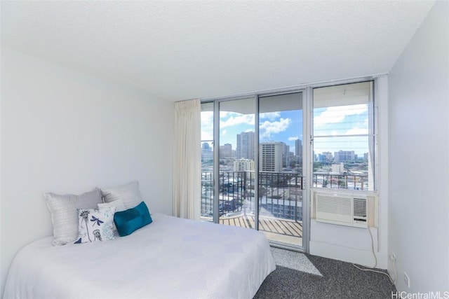 carpeted bedroom featuring cooling unit, access to exterior, expansive windows, and a textured ceiling