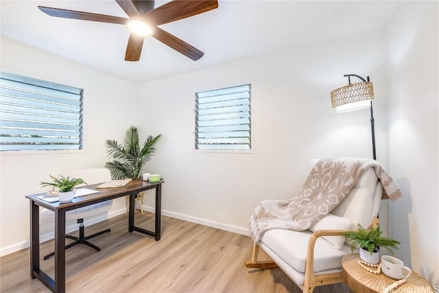 office with light wood-type flooring and ceiling fan