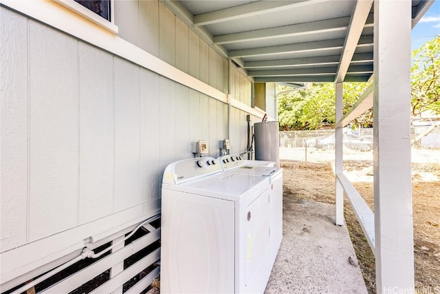 washroom with water heater and washing machine and clothes dryer