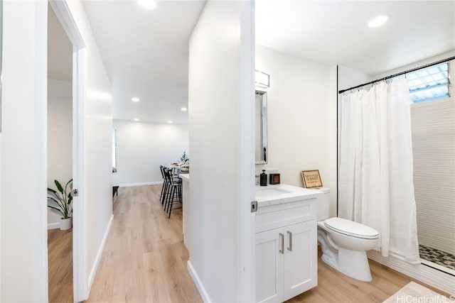 bathroom with curtained shower, vanity, wood-type flooring, and toilet