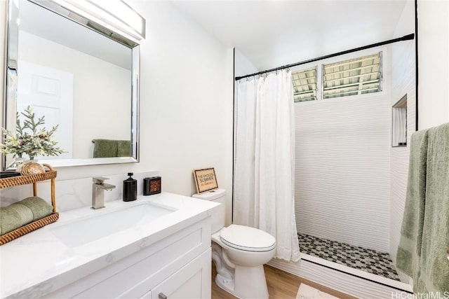 bathroom with walk in shower, hardwood / wood-style floors, vanity, and toilet