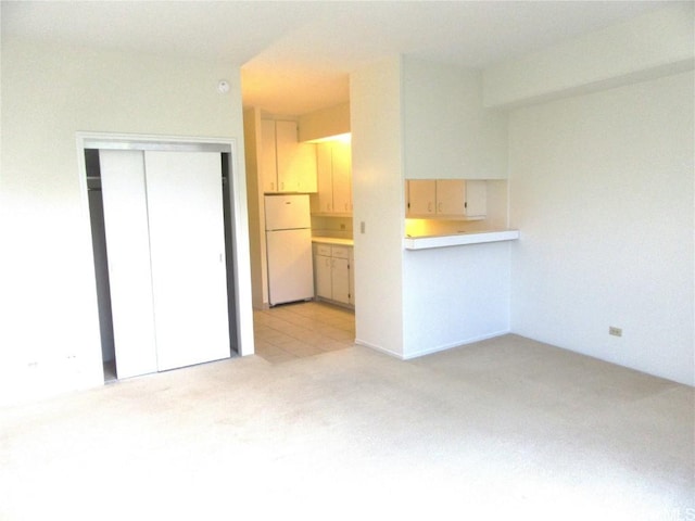 unfurnished living room featuring light carpet