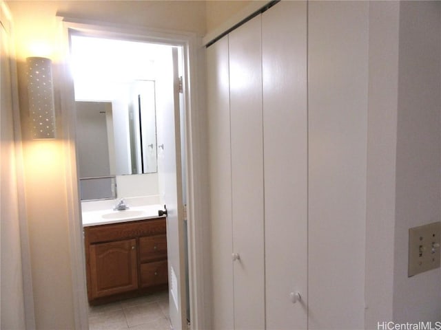 corridor featuring sink and light tile patterned flooring