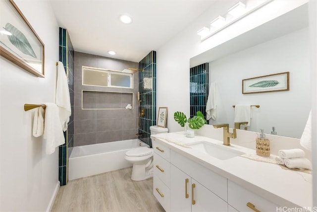 full bathroom with hardwood / wood-style floors, vanity, toilet, and tiled shower / bath