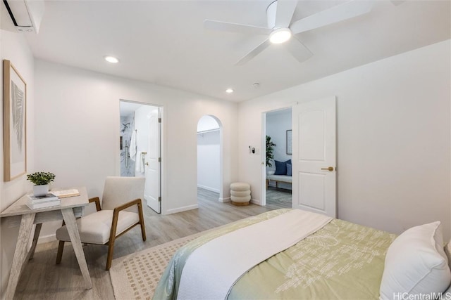 bedroom featuring ensuite bathroom, ceiling fan, and light wood-type flooring