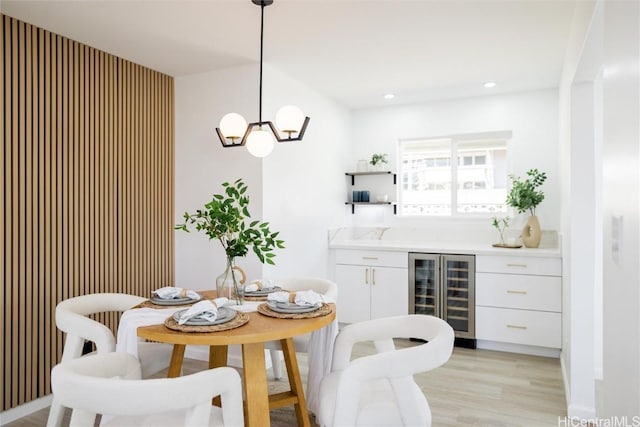 dining space with light hardwood / wood-style flooring and beverage cooler