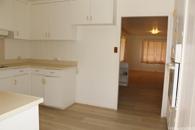 kitchen with light wood-type flooring and white cabinetry