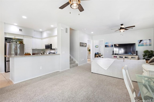 carpeted living room featuring ceiling fan