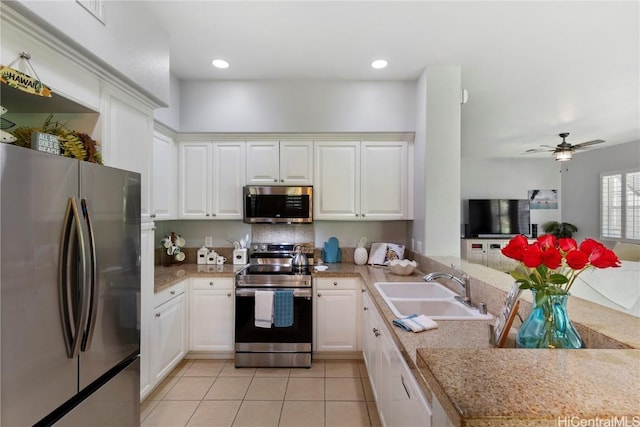 kitchen with kitchen peninsula, appliances with stainless steel finishes, ceiling fan, sink, and white cabinets