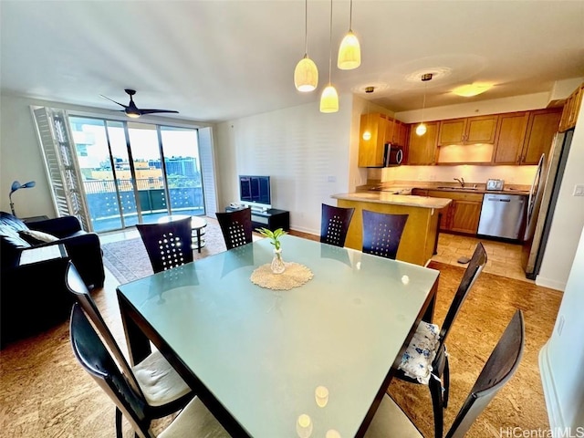 dining space with floor to ceiling windows, ceiling fan, and sink