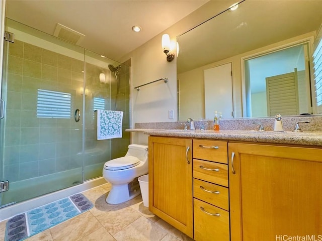 bathroom with tile patterned floors, vanity, toilet, and a shower with shower door