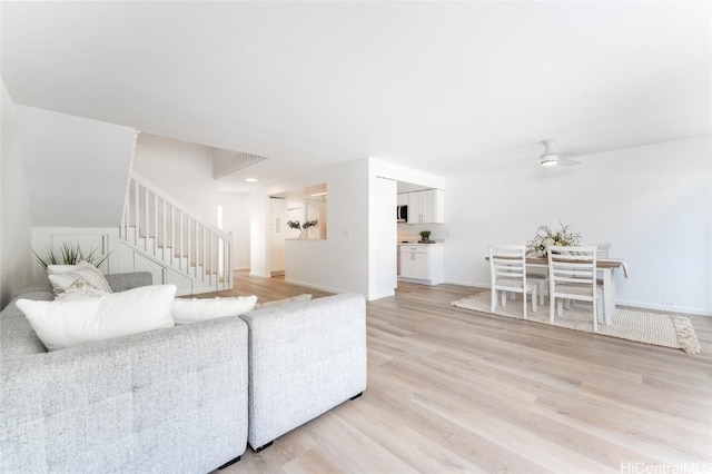 living room featuring ceiling fan and light hardwood / wood-style floors