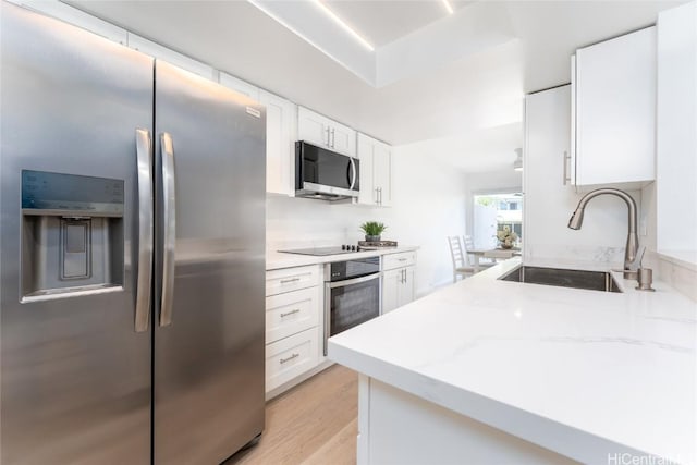 kitchen featuring white cabinets, light stone countertops, sink, and appliances with stainless steel finishes