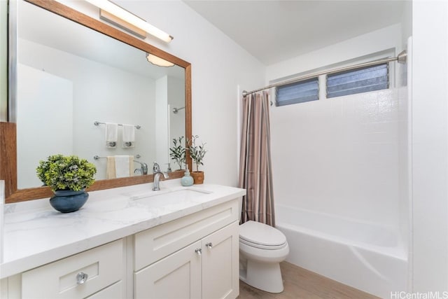 full bathroom featuring hardwood / wood-style flooring, vanity, toilet, and shower / tub combo