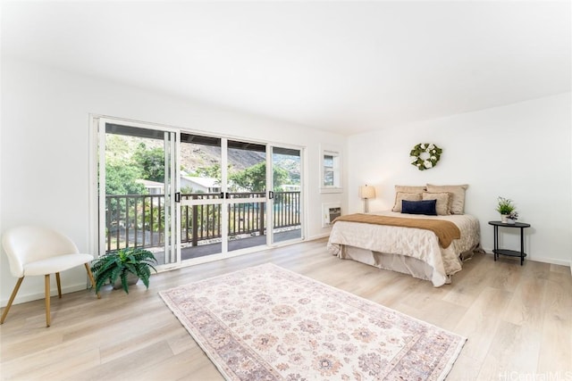 bedroom with access to outside and light hardwood / wood-style flooring