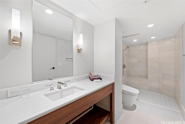 bathroom featuring tile patterned flooring, vanity, toilet, and a tile shower