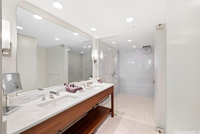 bathroom featuring tile patterned flooring, vanity, and tiled shower