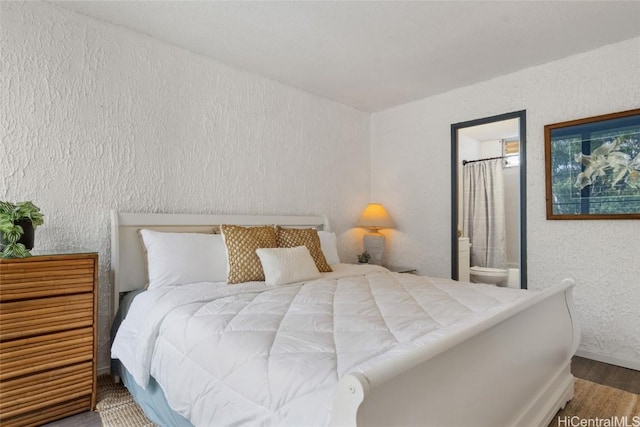 bedroom featuring wood-type flooring and connected bathroom