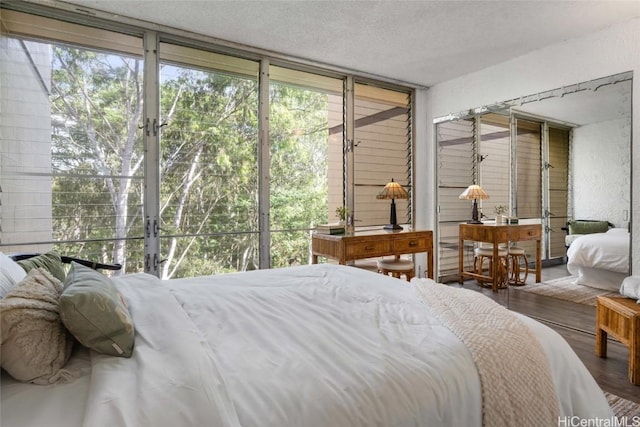 bedroom with hardwood / wood-style floors, expansive windows, and multiple windows