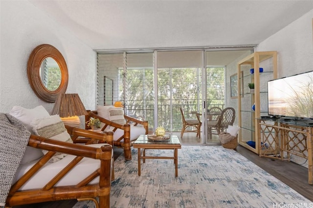 living area with hardwood / wood-style flooring and expansive windows