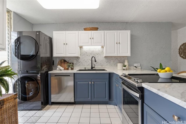 kitchen featuring white cabinetry, sink, stainless steel appliances, blue cabinets, and stacked washer and clothes dryer