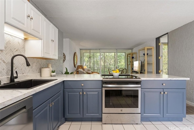 kitchen with blue cabinetry, white cabinetry, sink, stainless steel appliances, and kitchen peninsula