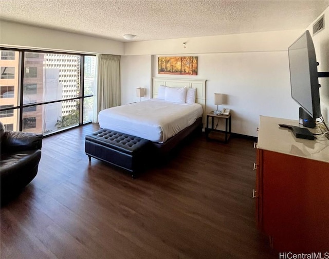 bedroom with a textured ceiling and dark wood-type flooring