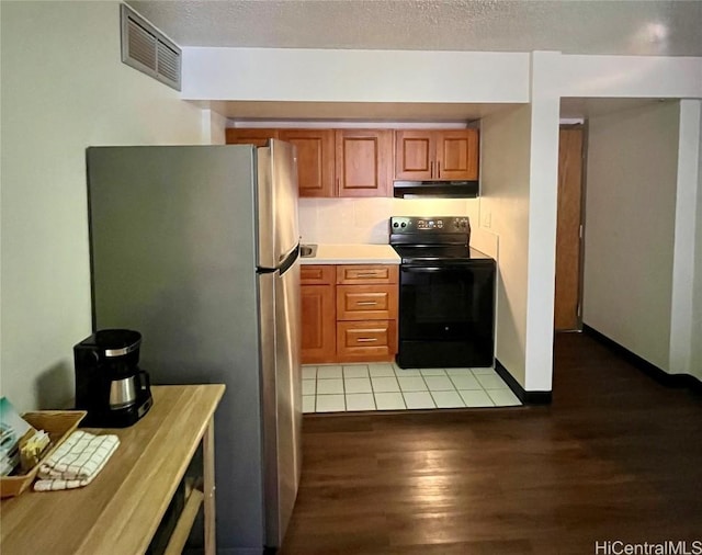 kitchen with stainless steel fridge, light hardwood / wood-style flooring, and black range with electric cooktop