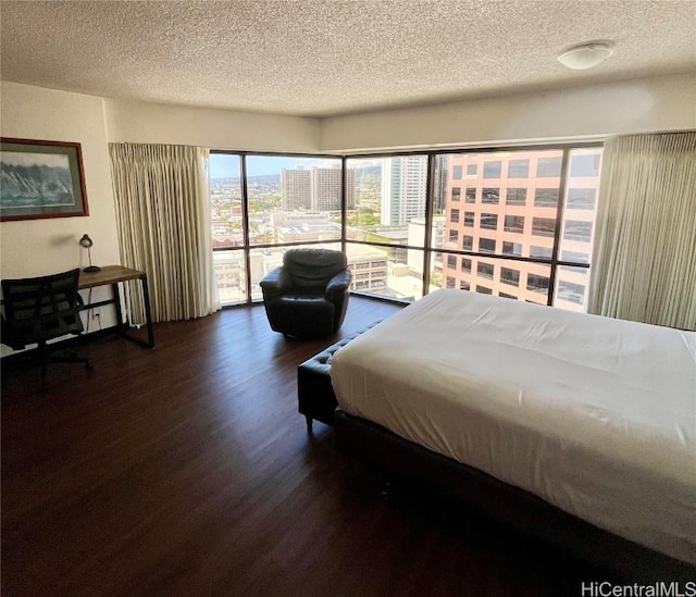 bedroom featuring a textured ceiling, access to exterior, and dark hardwood / wood-style floors