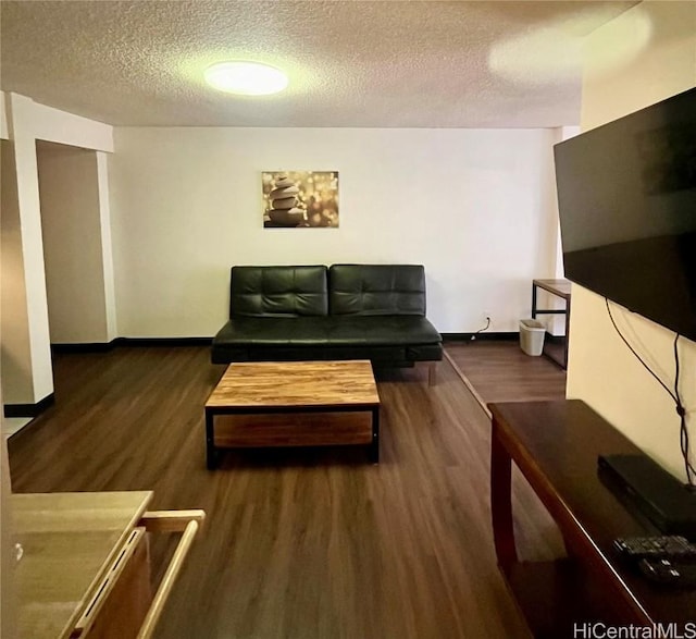 living room with dark wood-type flooring and a textured ceiling