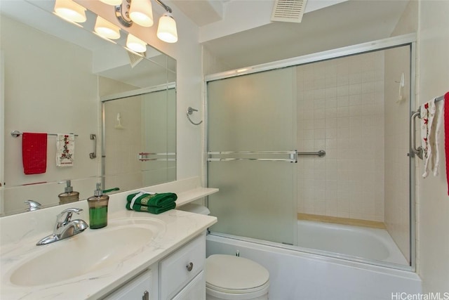 full bathroom with vanity, combined bath / shower with glass door, and toilet