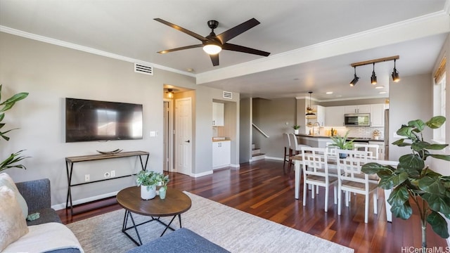 living room with ceiling fan, dark wood-type flooring, and ornamental molding