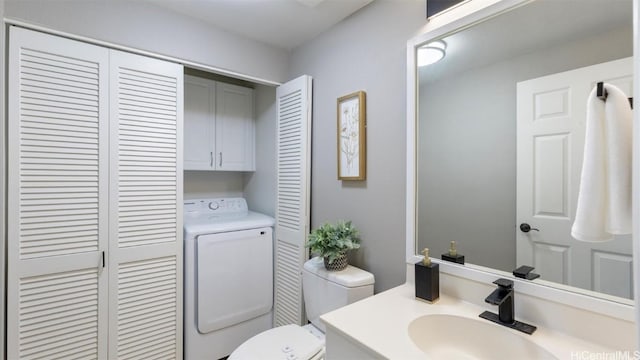 bathroom with washing machine and clothes dryer, vanity, and toilet