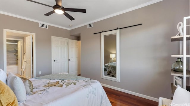 bedroom with crown molding, ceiling fan, a barn door, connected bathroom, and dark hardwood / wood-style flooring