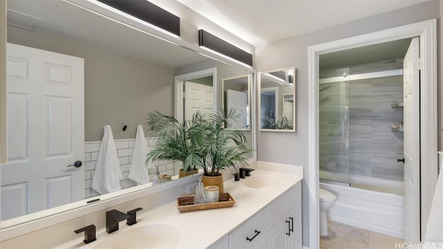 full bathroom featuring tile patterned flooring, vanity, toilet, and tiled shower / bath combo