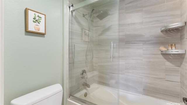 bathroom with shower / bath combination with glass door and toilet