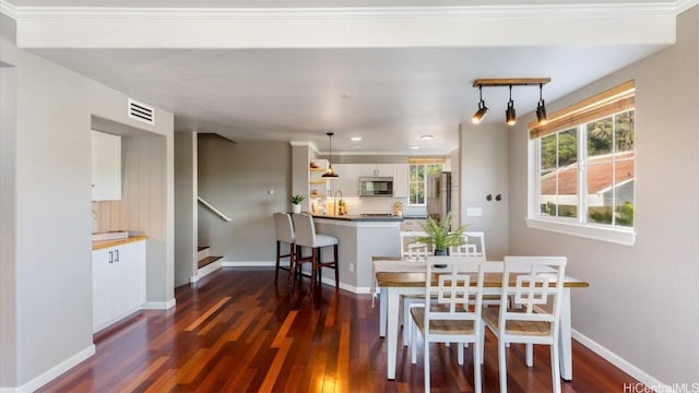 dining room featuring dark hardwood / wood-style floors and crown molding