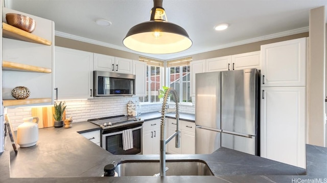 kitchen with white cabinetry, crown molding, appliances with stainless steel finishes, and tasteful backsplash