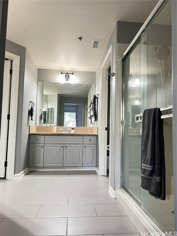 bathroom featuring tile patterned flooring, vanity, and an enclosed shower