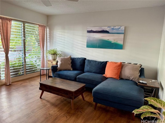 living room with hardwood / wood-style floors, a textured ceiling, and ceiling fan