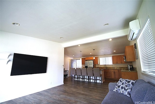 living room featuring an AC wall unit, dark hardwood / wood-style flooring, sink, and vaulted ceiling