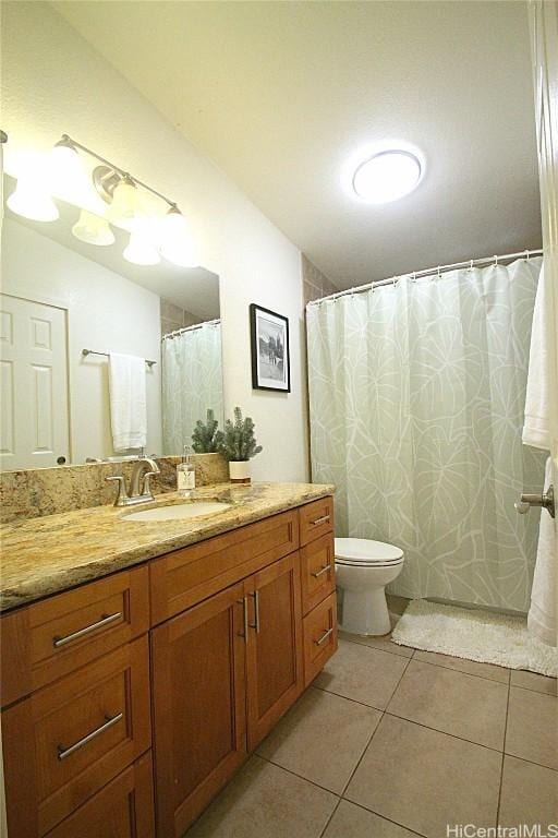 bathroom featuring toilet, tile patterned flooring, and vanity