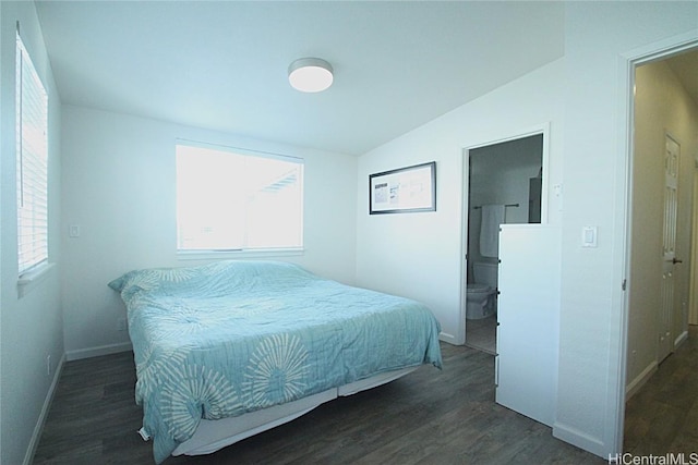 bedroom with dark wood-type flooring, ensuite bathroom, and lofted ceiling