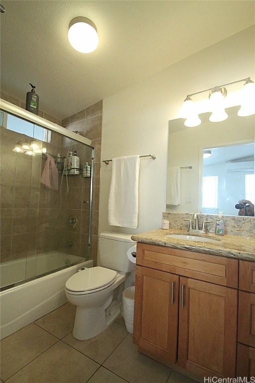 full bathroom featuring vanity, toilet, combined bath / shower with glass door, and tile patterned floors