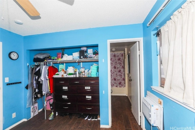 interior space with ceiling fan, dark wood-type flooring, and a wall mounted air conditioner