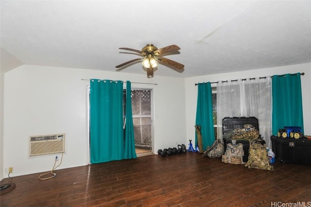 interior space with a wall mounted AC, ceiling fan, and dark wood-type flooring